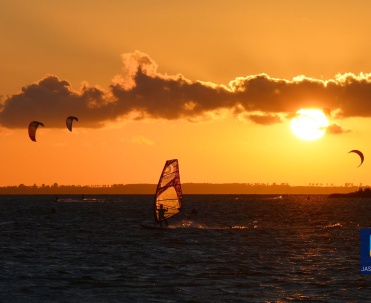 Windsurfing i kitesurfing o zachodzie słońca.